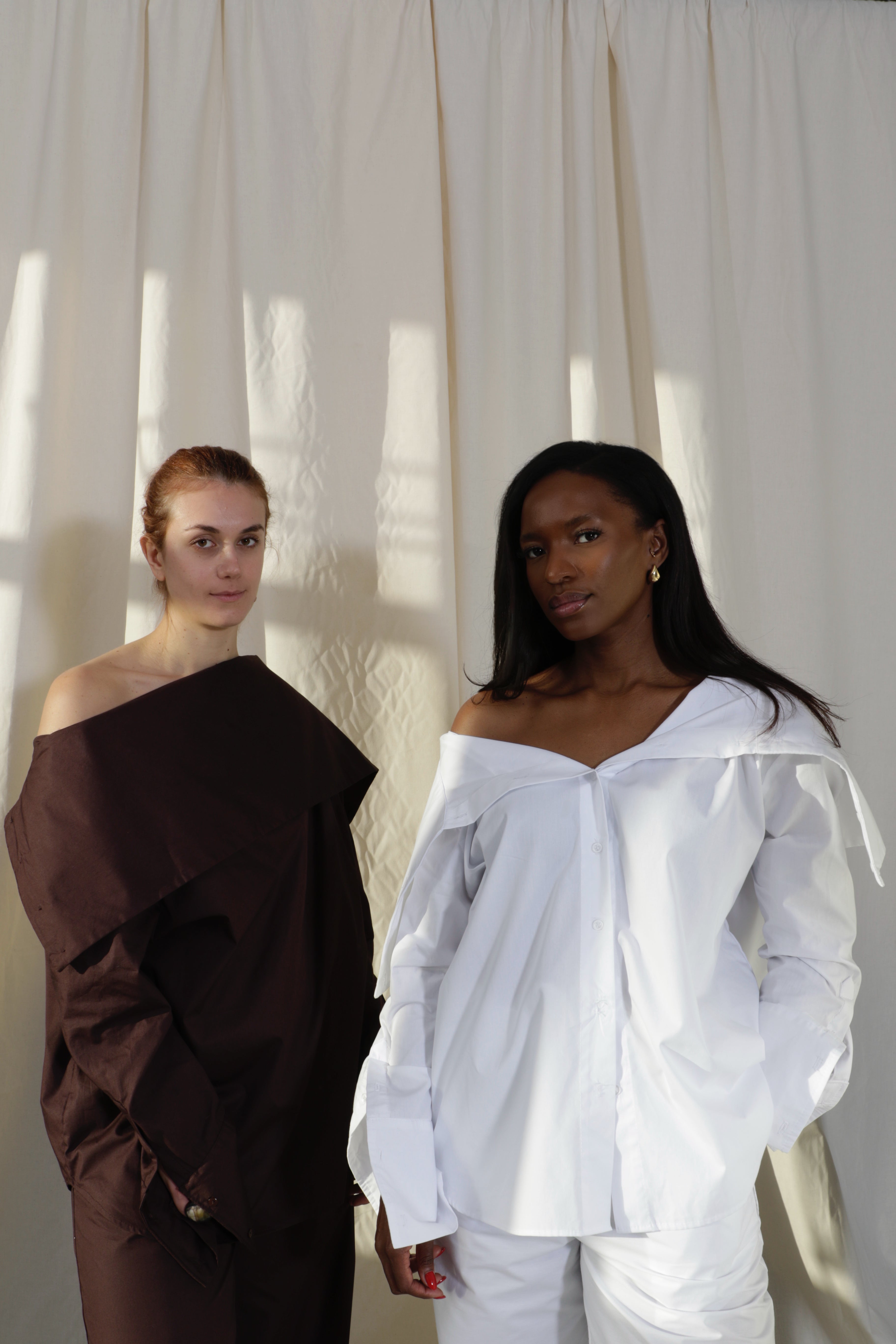 Woman wearing a pure cotton espresso brown and crisp white shirt worn both ways by Kureé The Brand Womenswear standing against a draped backdrop